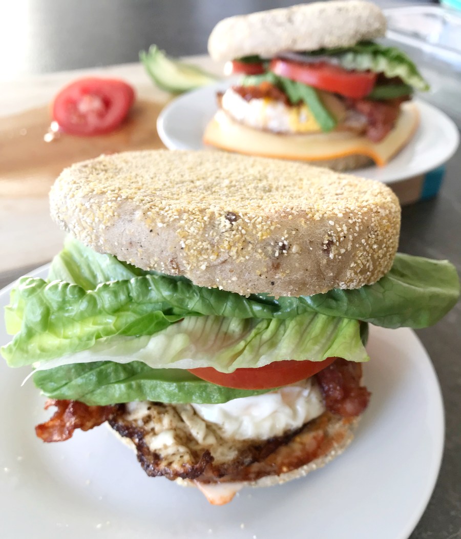 Easy breakfast sandwich added to a plate with another sandwich in the background.