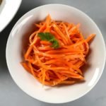 Korean spiced carrot salad served in a bowl with another bowl to the side.