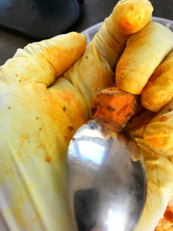 Scraping turmeric with a spoon