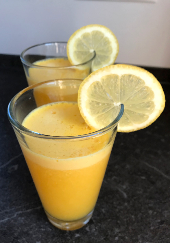 Orange juice served in a glass with a slice of lemon