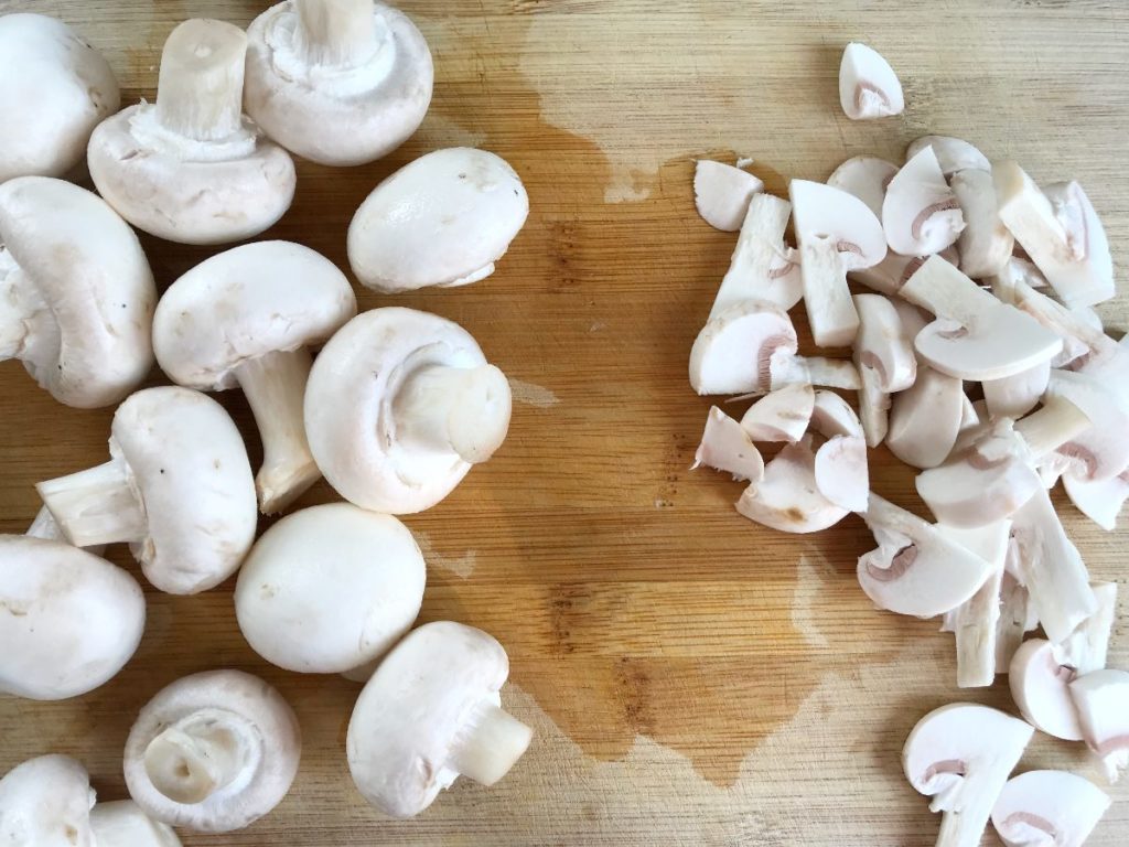 Sliced mushrooms on a cutting board.