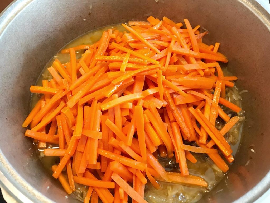 Plov topped with sauteed carrots