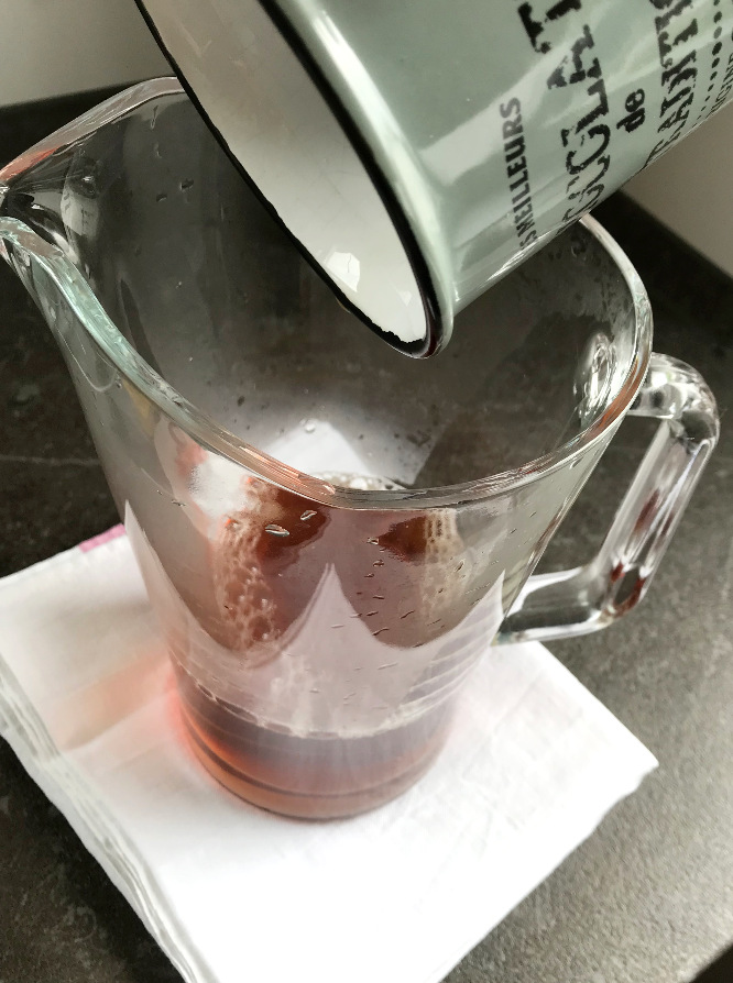 Black tea poured into glass pitcher