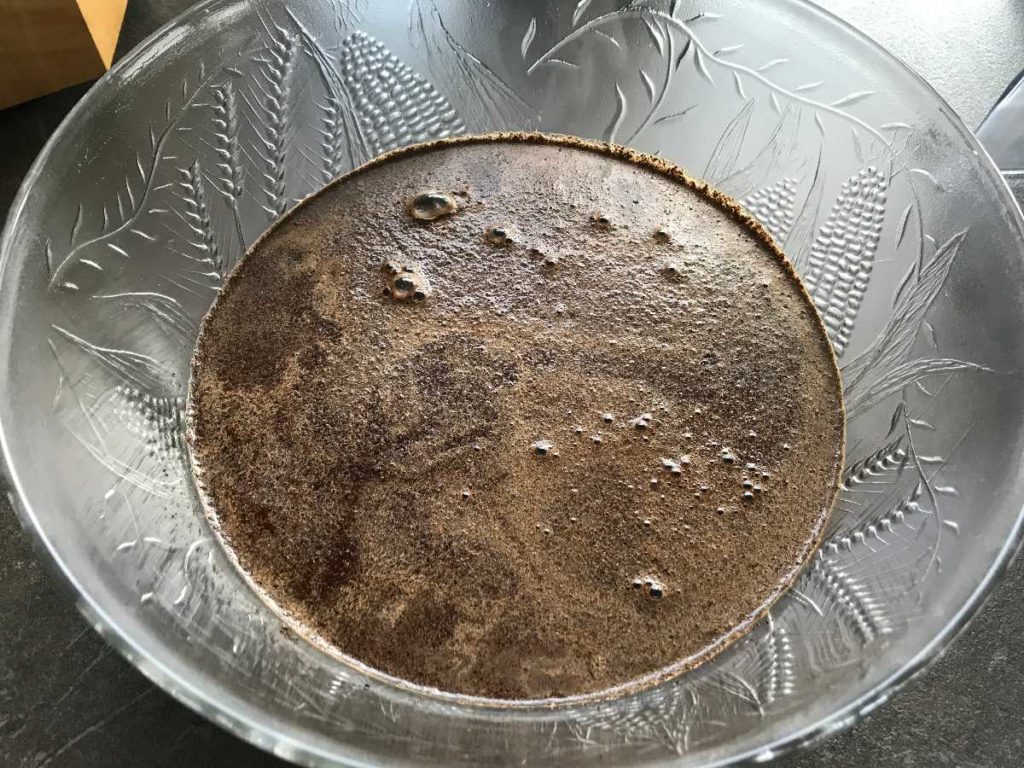 Coffee grounds with water mixed in a bowl