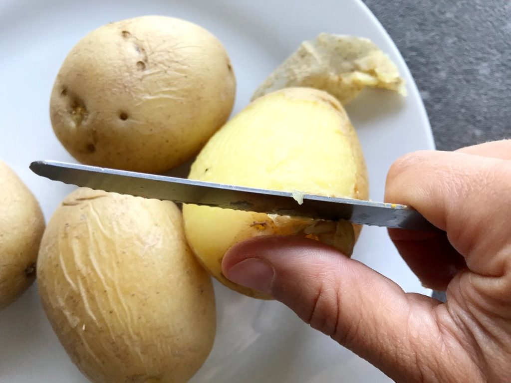 Peeling cooked potatoes with a knife