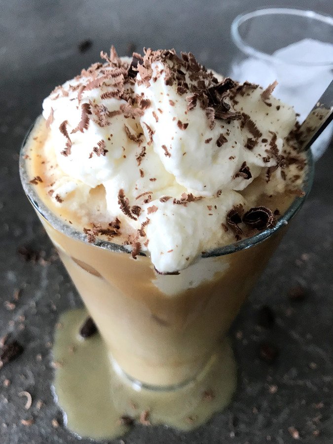 Cold brewed coffee with whipped cream and chocolate shavings