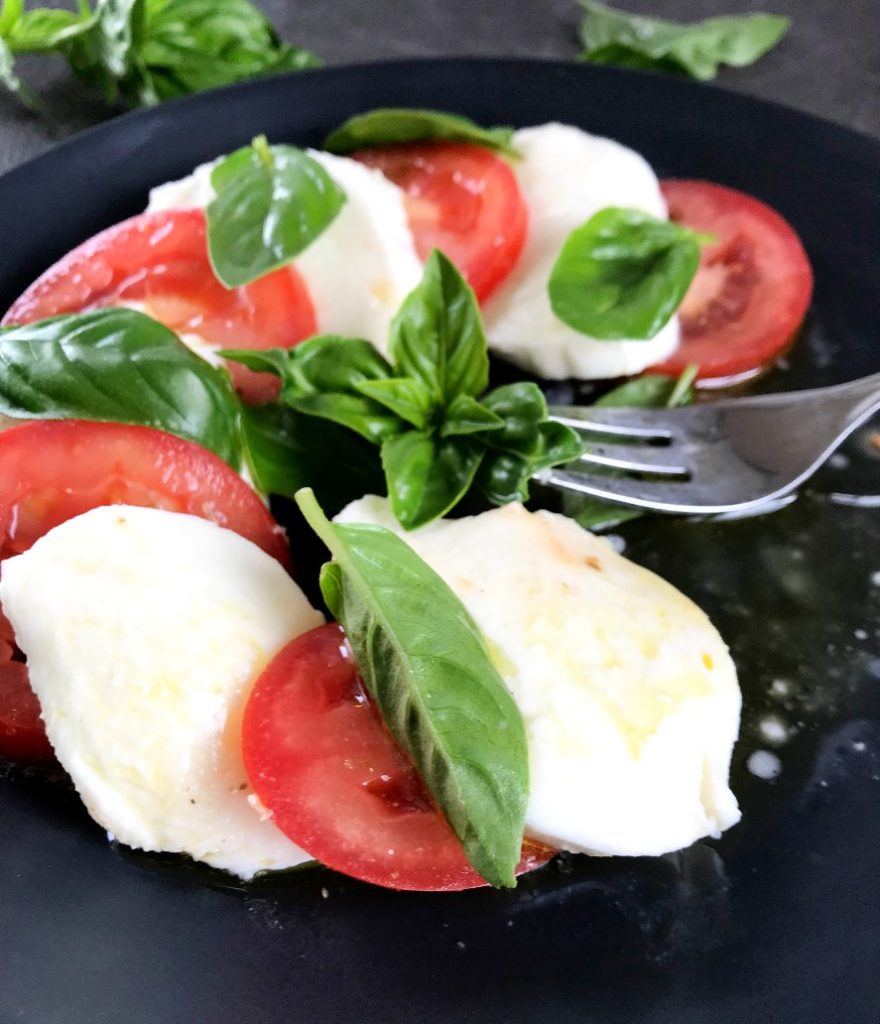 Tomato and Mozzarella Plate sprinkled with Olive Oil on a plate