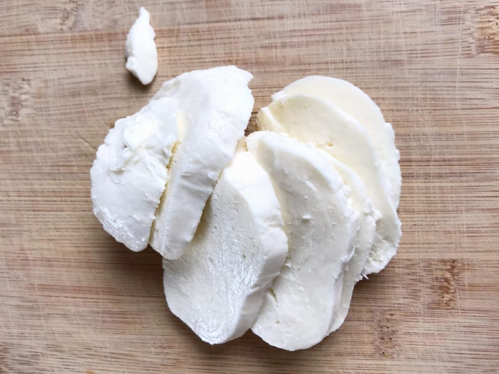 Slices of Mozzarella cheese on a cutting board