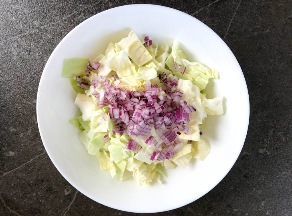 Red onion added to chopped cabbage