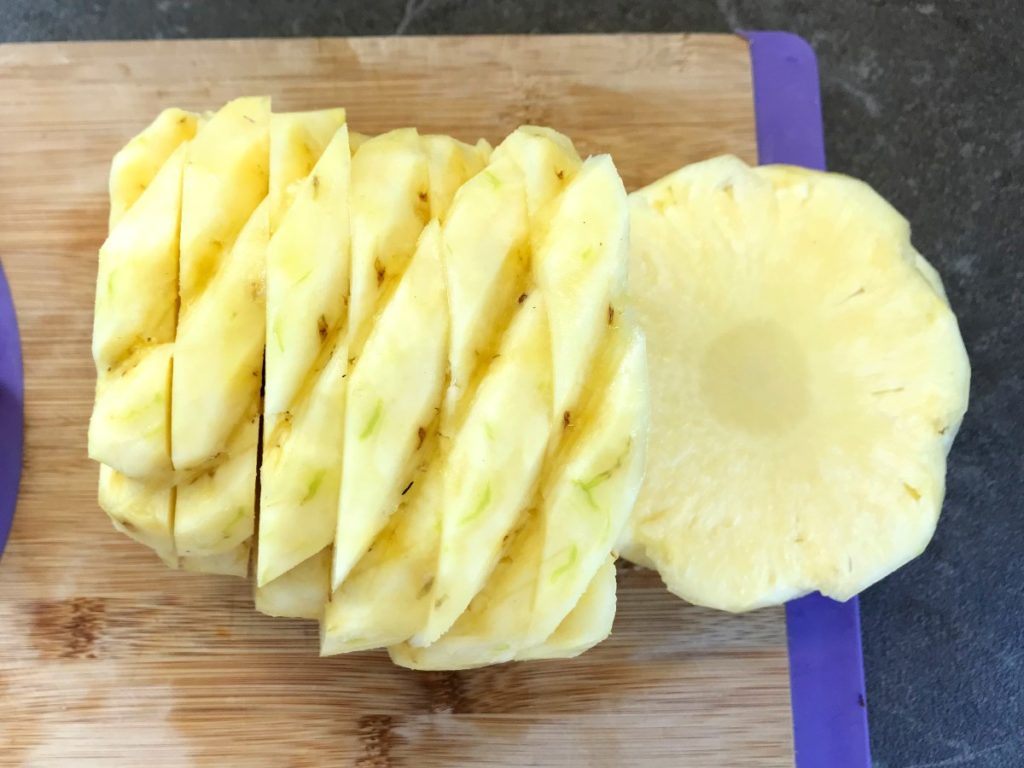 Pineapple sliced on cutting board