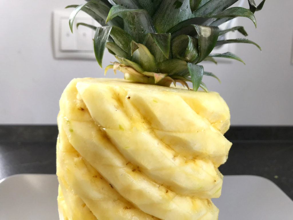 Leaves of pineapple added to the top of pineapple with a toothpick