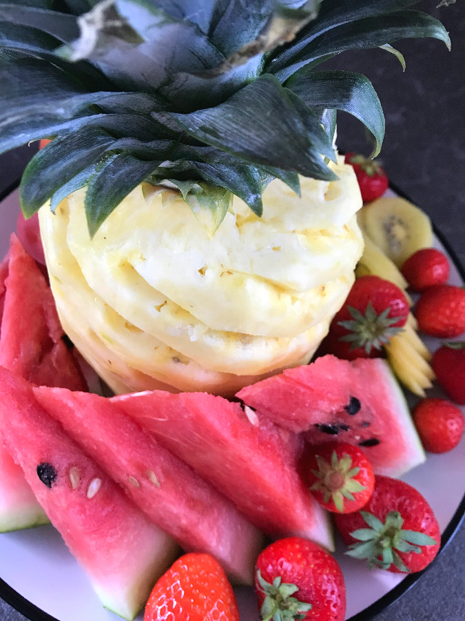 Cut pineapple with watermelon strawberries and other fruit arranged