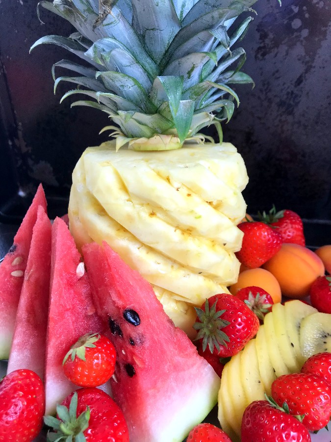 Beautifully cut pineapple on platter with fruit