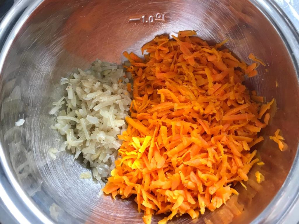 Sautéed carrots and onions in a bowl.