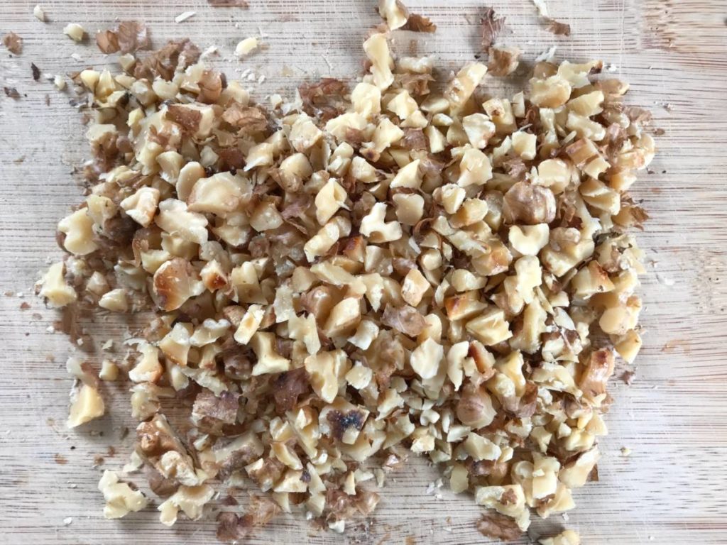 Roasted walnuts chopped on a cutting board