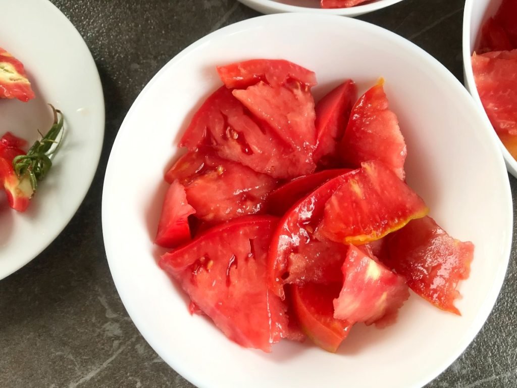 Tomatoes cut into bite sizes slices in a bowl.