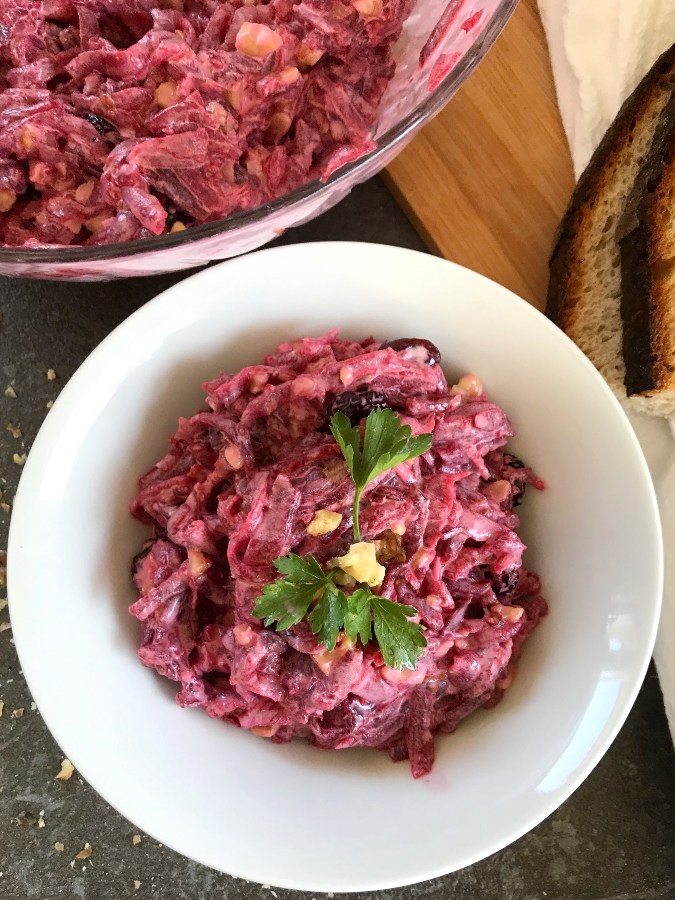 Red beet salad served in a bowl with bread