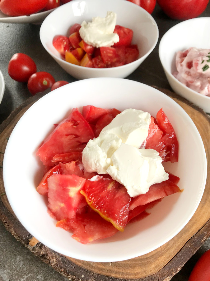 Cut tomatoes and sour cream for tomato salad recipe
