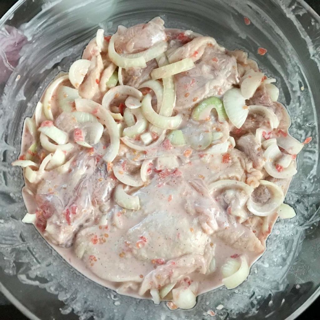Chicken thigh meat prepared for marinating in a bowl.