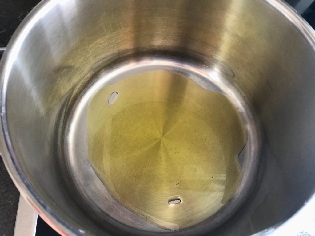 Olive oil heating in a medium sized pot.