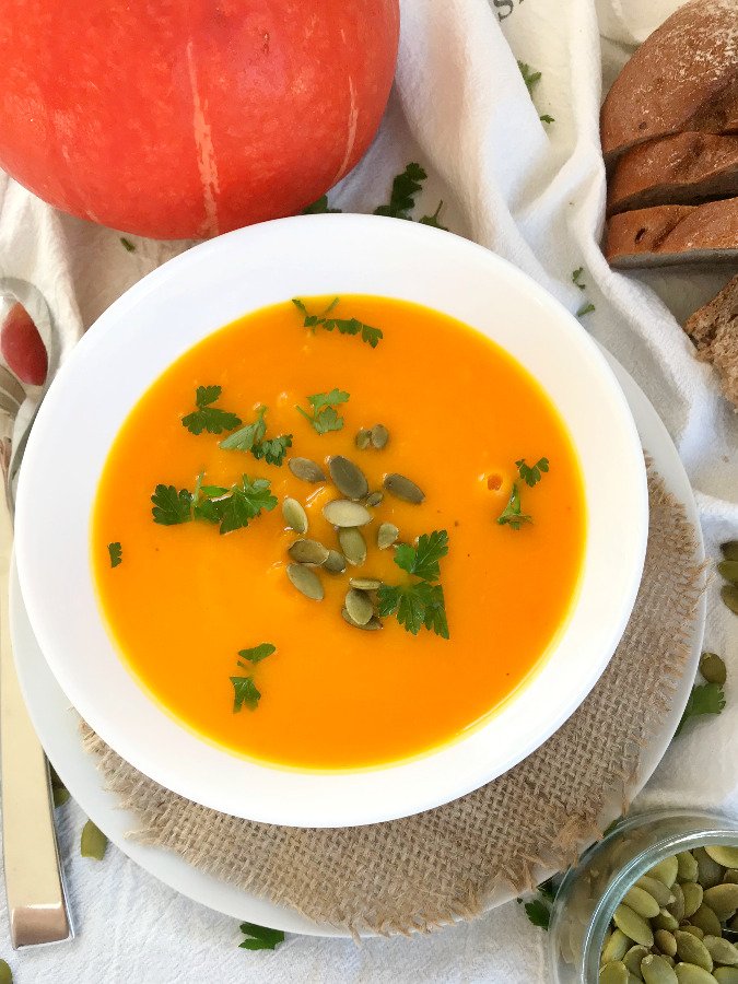 Creamy red kuri squash soup served in a bowl.