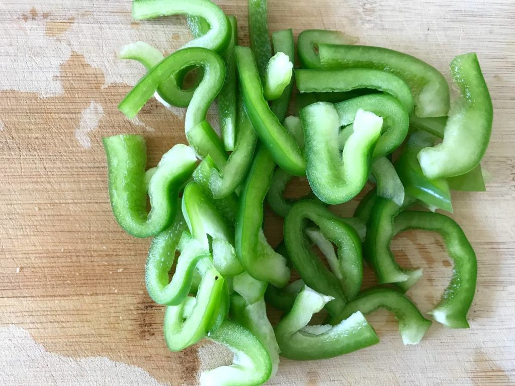 Sliced green bell pepper on a cutting board.