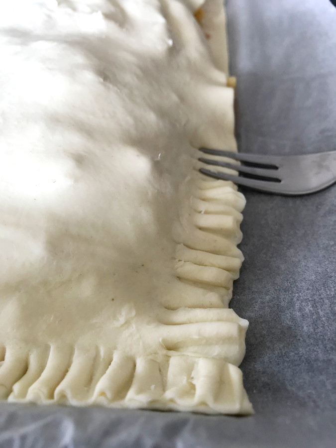Puff pastry edges pinched shut with a fork.