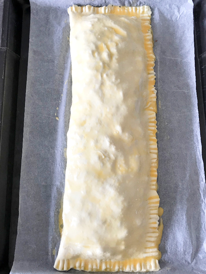 Puff pastry brushed with egg wash on a baking sheet.