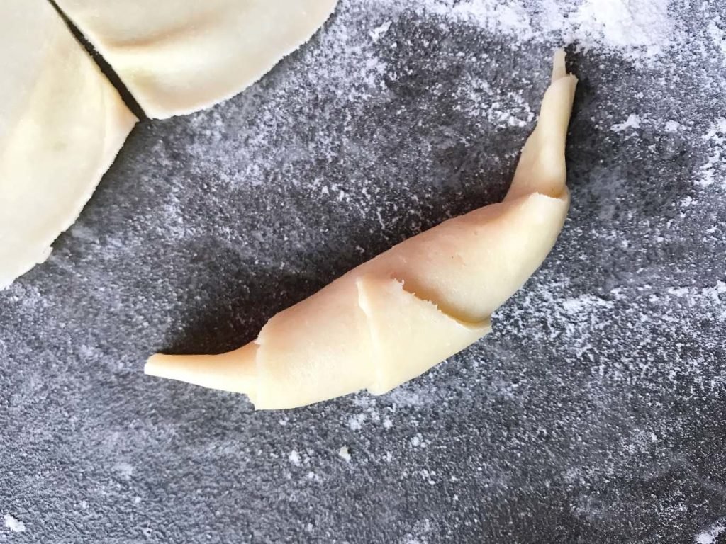 Finished rugelach cookie on a floured counter.