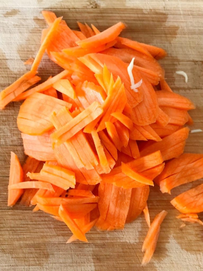 Shredded carrots on a cutting board.
