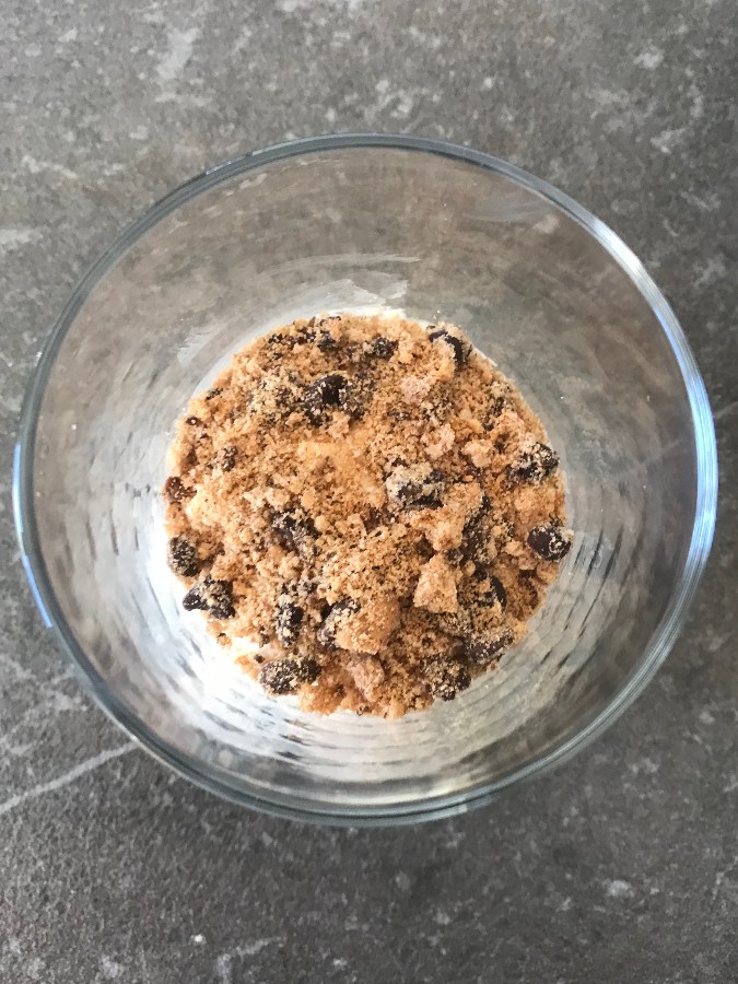 Crushed cookie layer added to dessert glass.