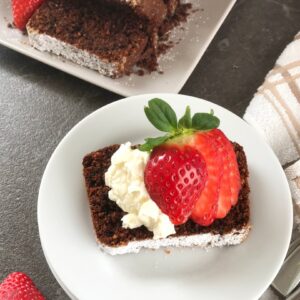 Hot Chocolate cake served on a plate with strawberries and whipped cream.