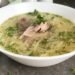 Egg noodle soup with chicken served in a white bowl