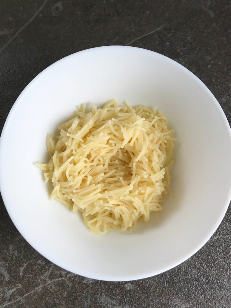 Cooked egg noodles in a white bowl