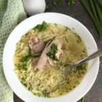 Egg noodle soup with chicken served in a white bowl