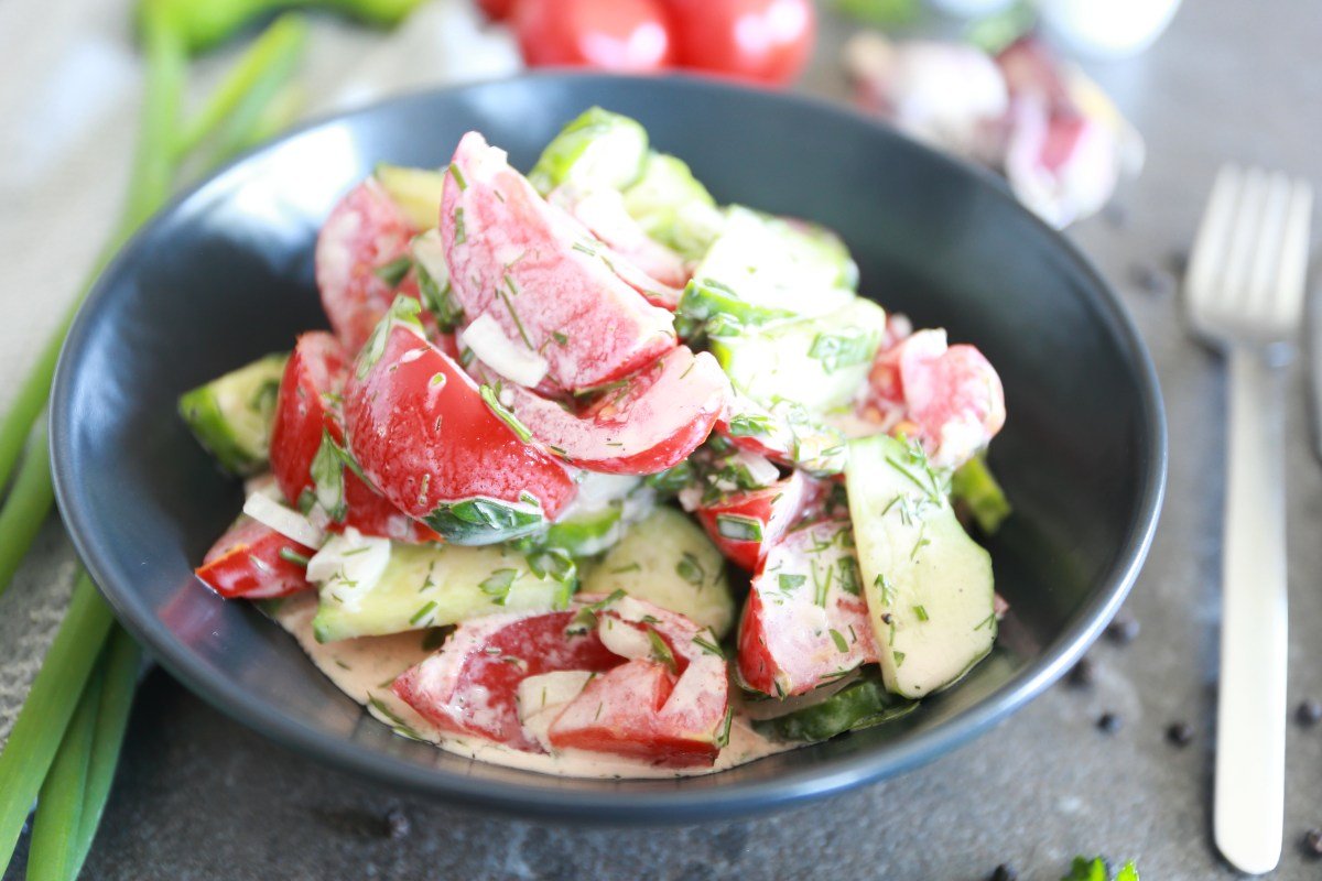 Creamy Cucumber Tomato Salad served in a charcoal colored bowl.