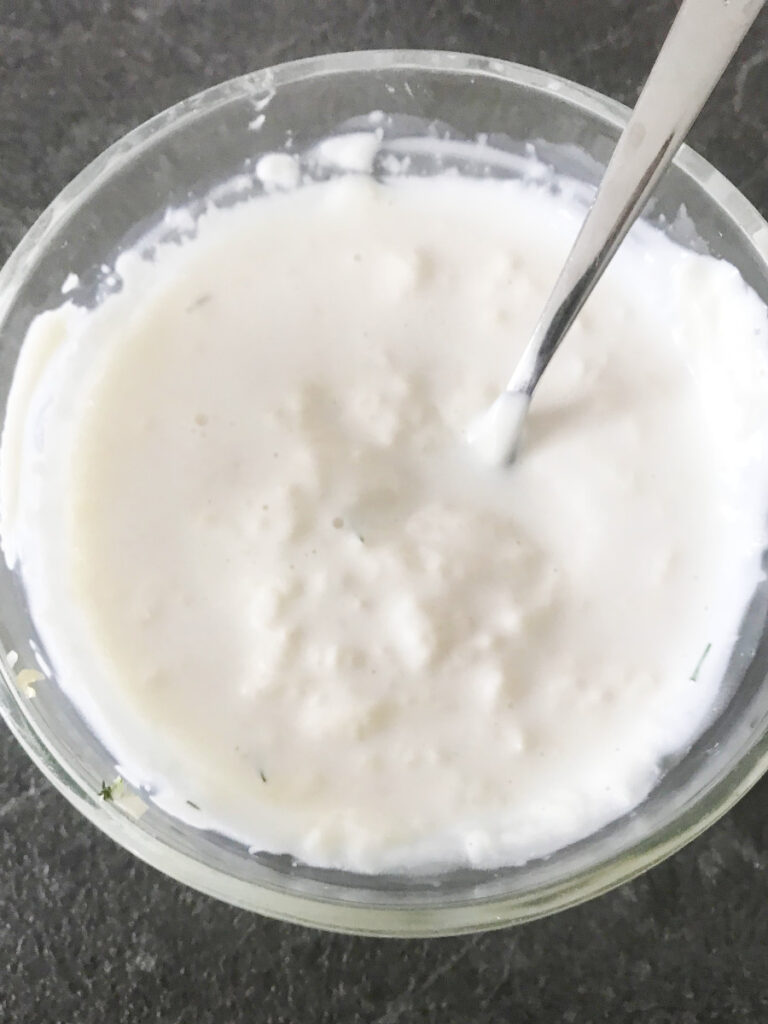 Mayo garlic sauce for zucchini appetizers in a clear bowl.
