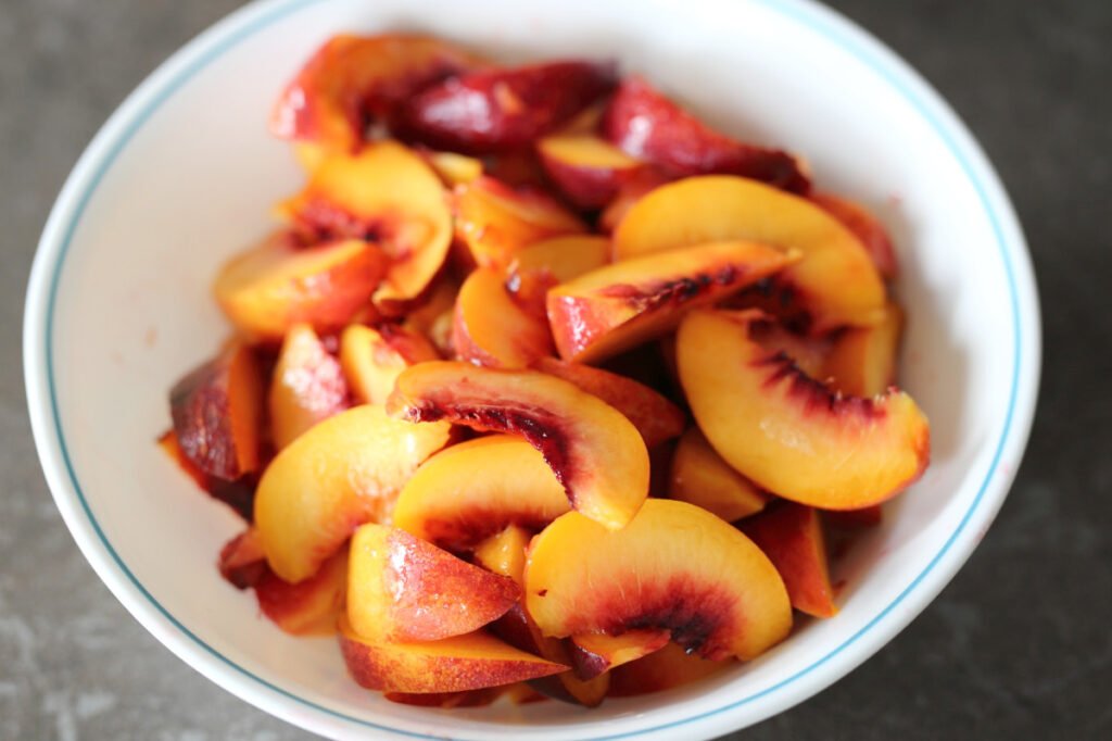 Washed and sliced nectarines in a bowl.