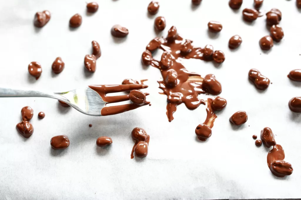 Chocolate covered coffee beans setting on a baking sheet
