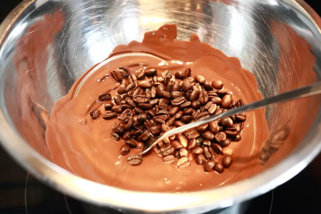 Coffee beans in melted chocolate in a double boiler.