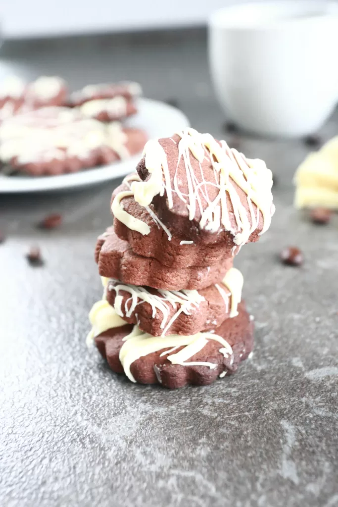 A stack of coffee cookies with more cookies in the background.