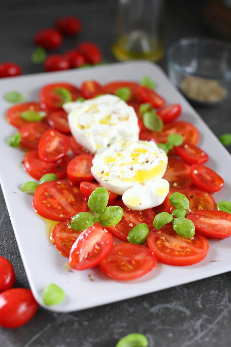 Burrata Caprese arranged on a plate.