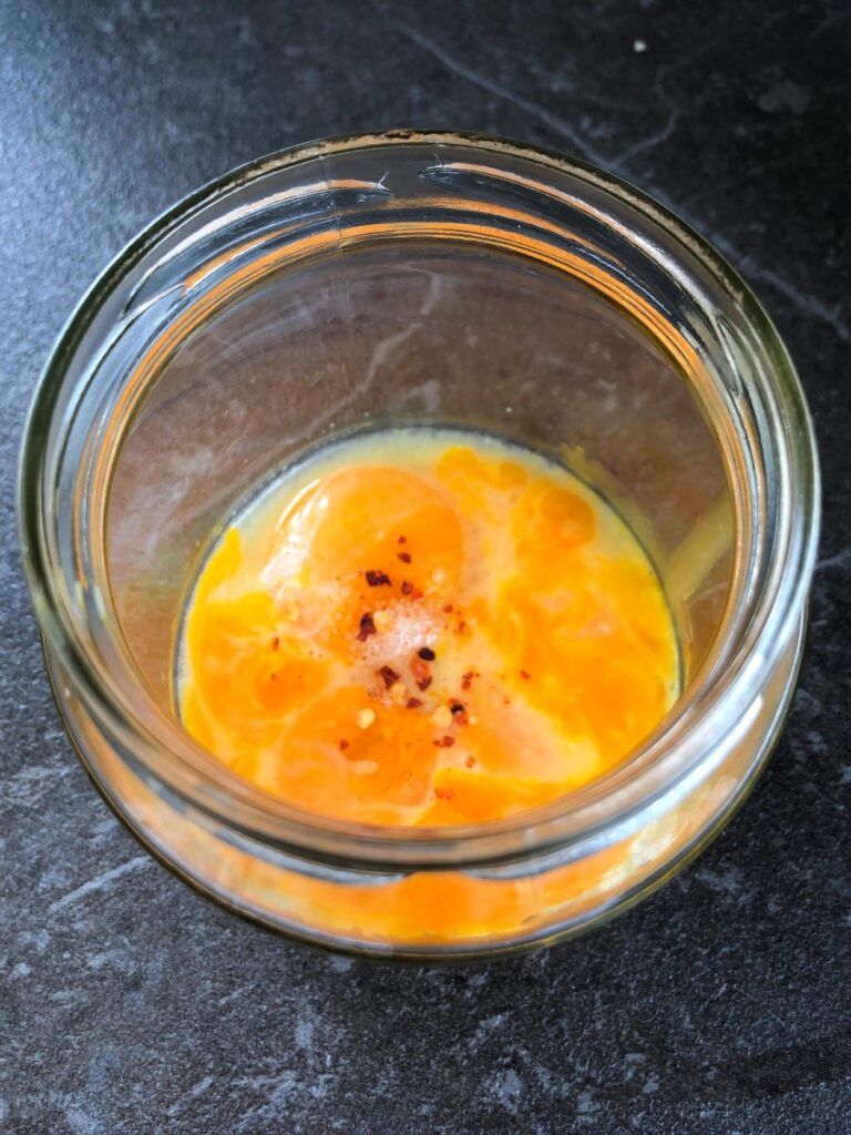 Egg yolks lemon juice and seasonings for hollandaise sauce in a jar.
