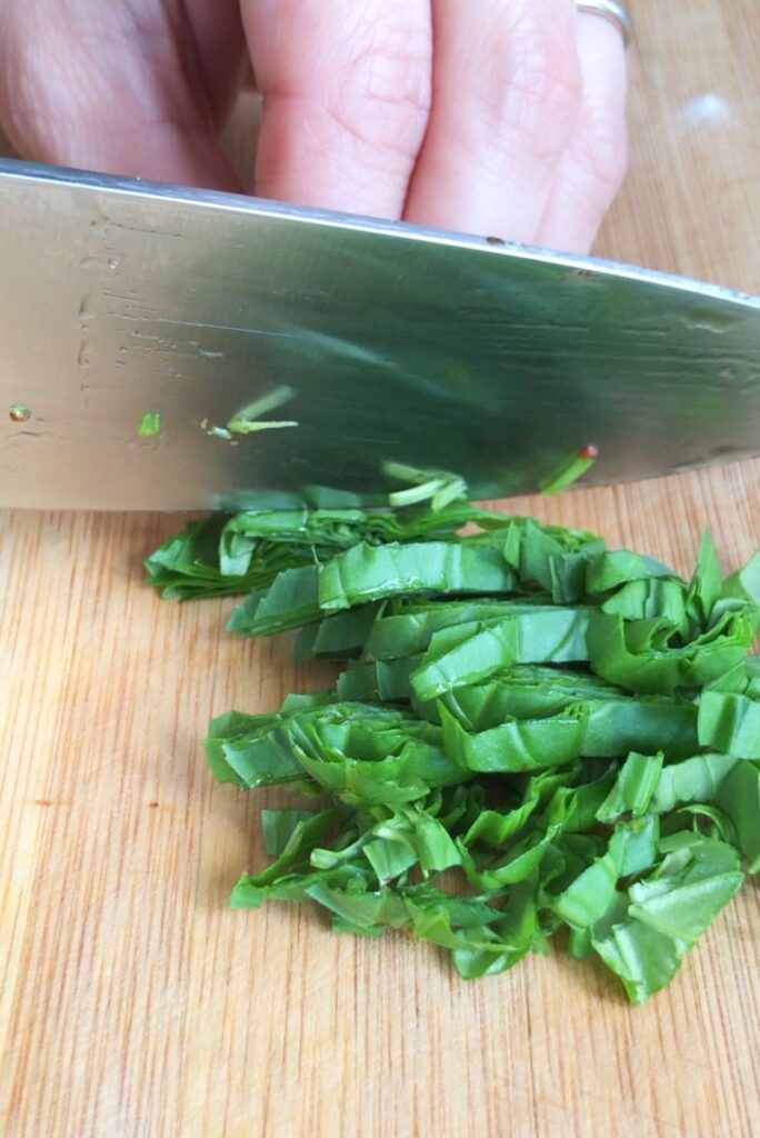 Chiffonaded basil on a cutting board.