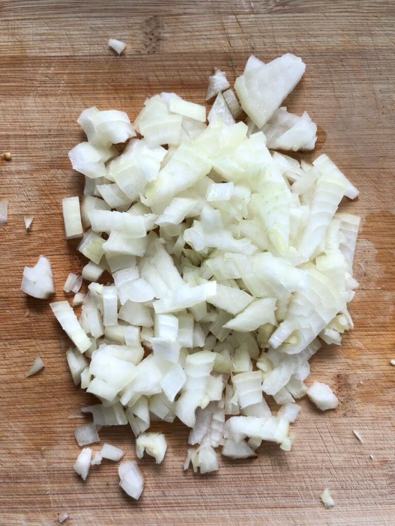 Chopped onion on a cutting board.