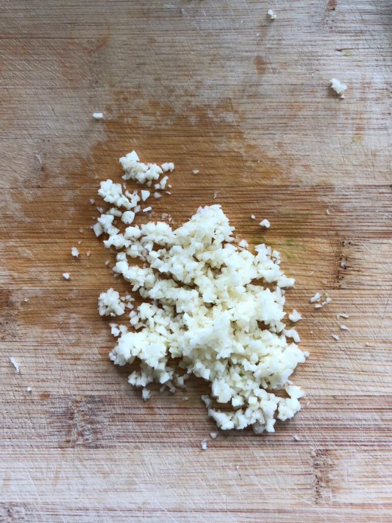 Minced garlic on cutting board.