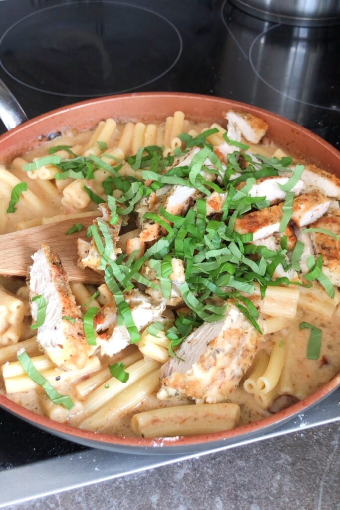 Marry me chicken pasta in a skillet ready to be mixed.