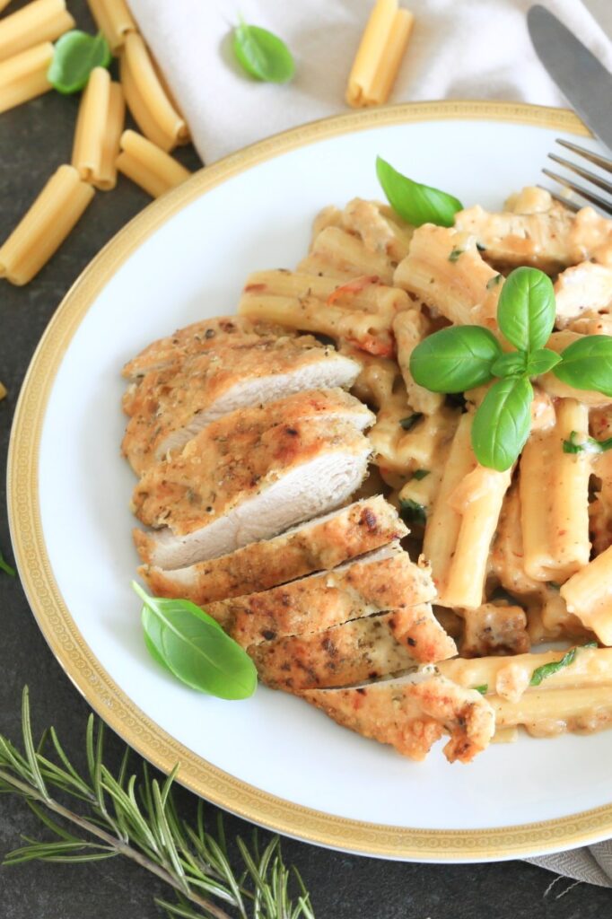 Marry me chicken pasta served on a plate and garnished with basil.