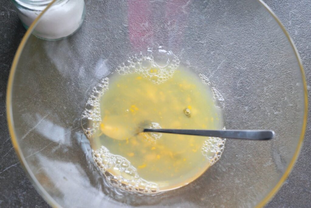 Beat egg in water with salt for pelmeni dough