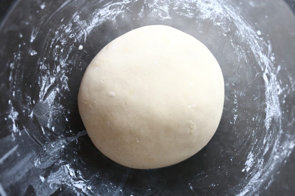 Finished Pelmeni dough in a glass mixing bowl